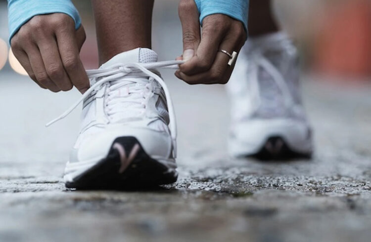 a runner lacing up shoes